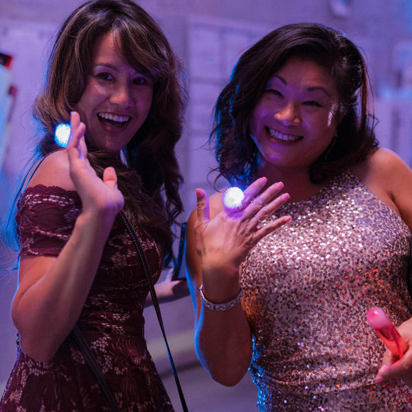 Two women posing with light up rings at the Sidecar Loading Dock After Party
