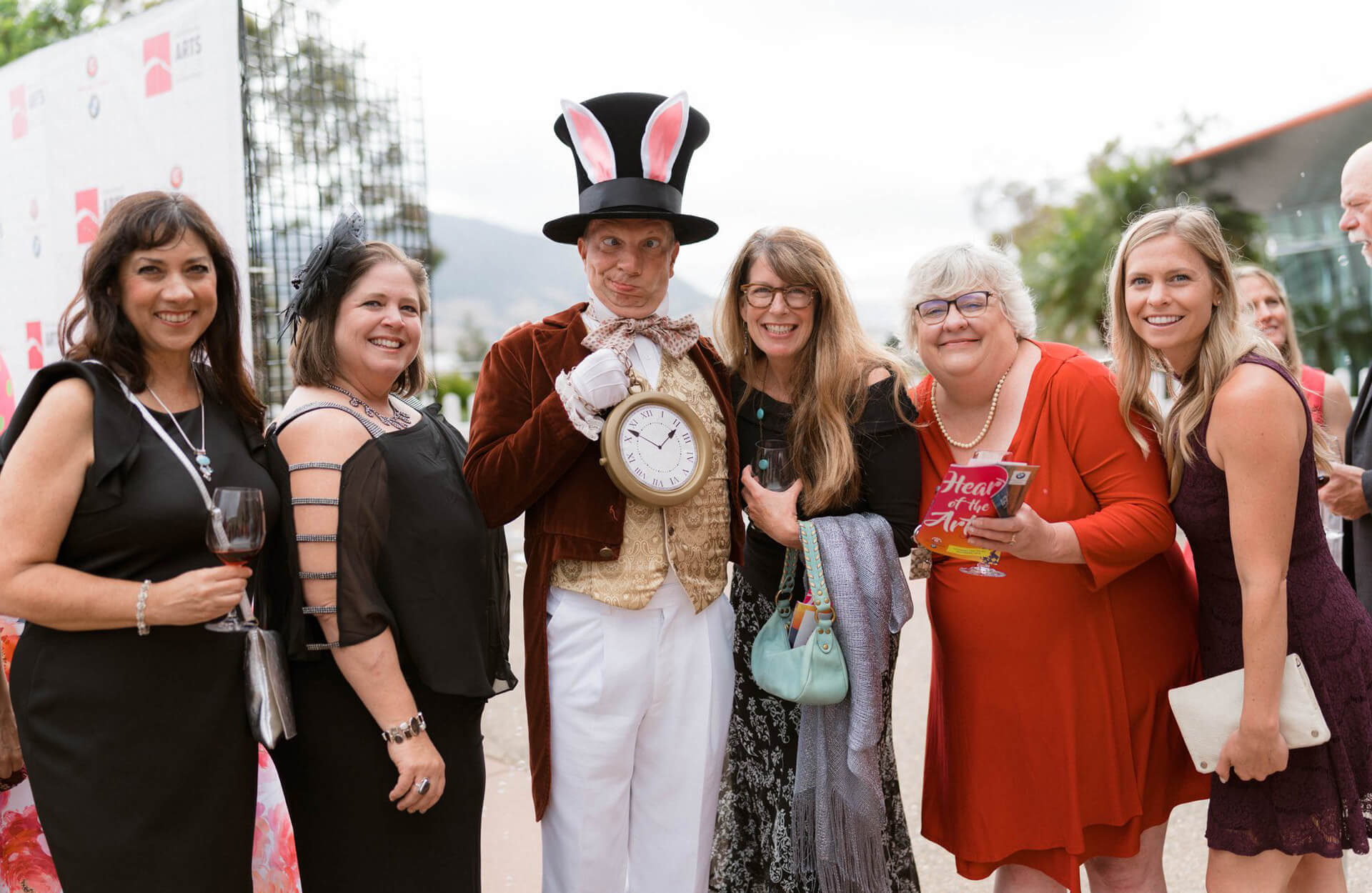 Group of people posing with the Mad Hatter at the Heart of the Arts Gala